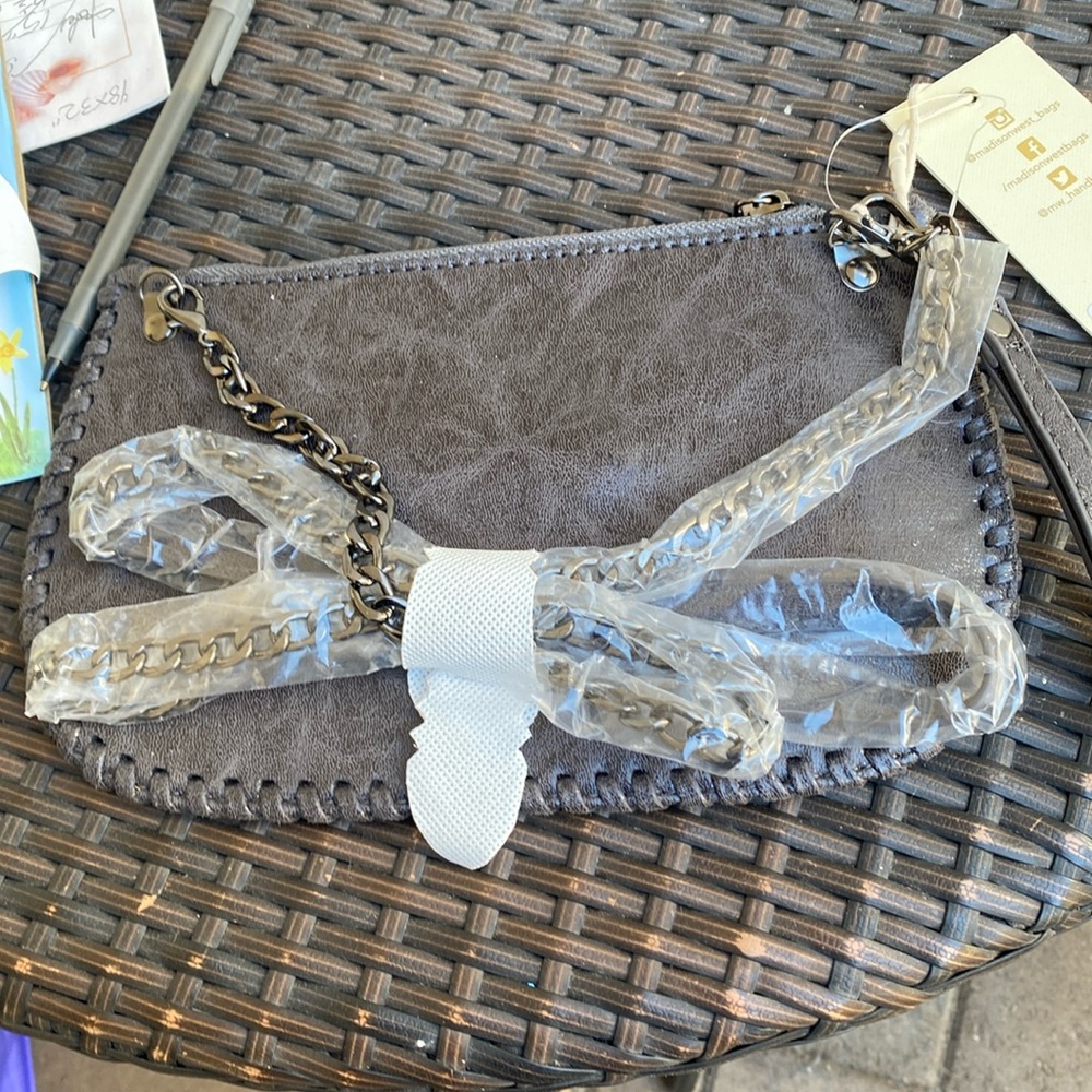Madison west grey faux leather crossbody with wristlet option. NWT metallic trim